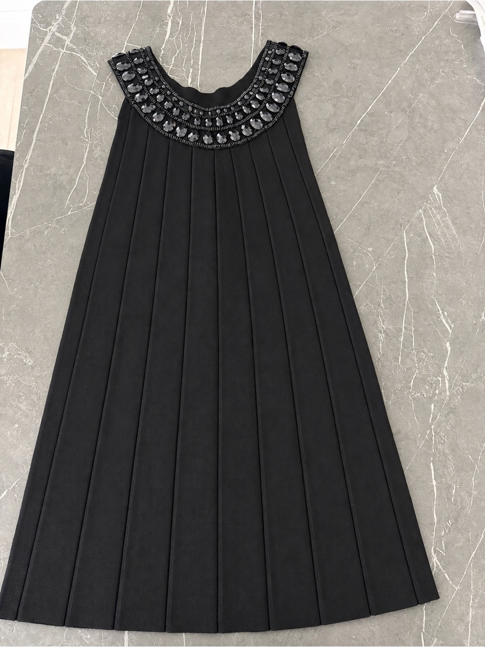 Black knit  mini dress with beading embellishments around collar.